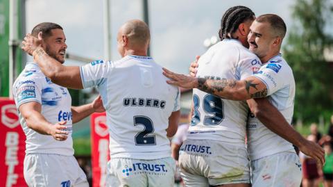 Mathieu Jussaume of Toulouse celebrates with Ethan Quai-Ward, Paul Ulberg and Jake Shorrocks after scoring a try, with the players wearing their all-white kit