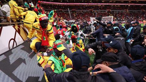 Security personnel block angry fans over a penalty decision against Senegal during the Africa Cup of Nations final