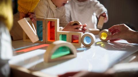 A children's nursery with children playing with colourful wooden blocks