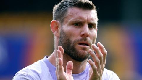 James Milner applauds supporters after a football match