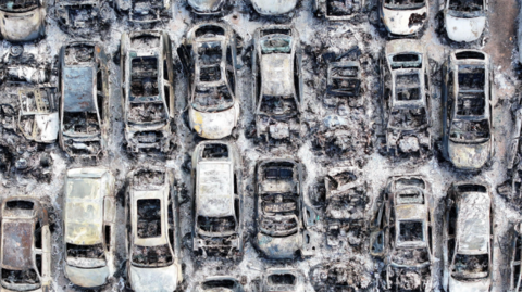 An aerial image of rows of cars burned in a fire.