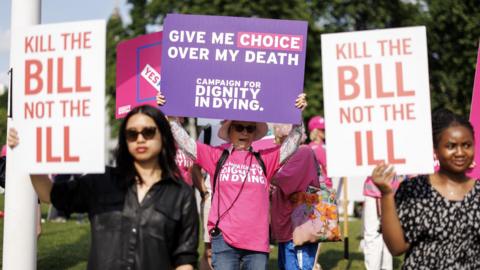 Campaigners for and against assisted dying hold placards outside Parliament reading "kill the bill not the ill" and "give me choice over my death".