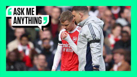 Marin Odegaard walks off pitch with physio with green Ask Me Anything banner surrounding