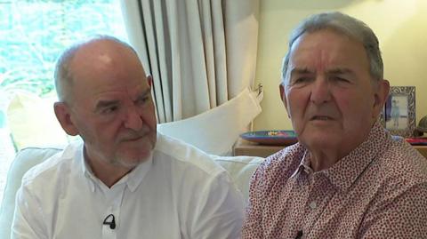 Brothers Anthony (left) and Eamonn (right) McNamara, sitting next to each other on a sofa.