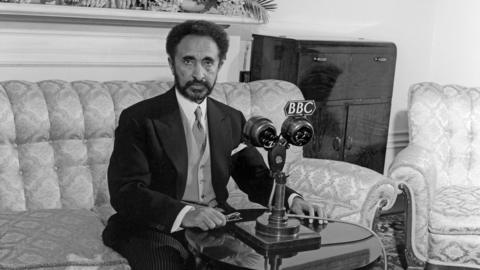 His Imperial Majesty Haile Selassie I, Emperor of Ethiopia, sitting on a sofa with a 鶹ҳ microphone in front of him