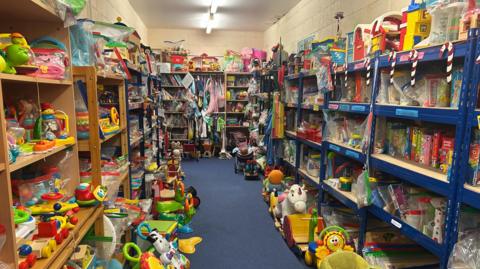 A room with shelves on each side stacked high with colorful childrens toys