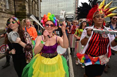 People in colourful costume playing musical instruments 