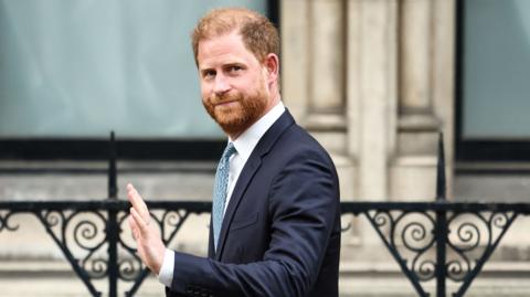 Prince Harry, Duke of Sussex waves as he leaves the High Court, in central London, on April 8, 2025 after an hearing about a government decision to downgrade his personal security during visits in Britain. 