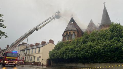 Firefighters tackling a blaze at a Gothic building