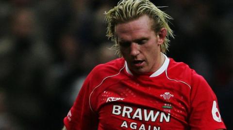 Alix Popham is pictured wearing his Wales shirt on the pitch during a game. 