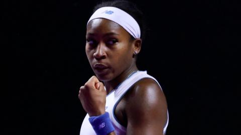 Coco Gauff clenches her fist in celebration after winning a point against Jasmine Paolini
