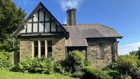 A Victorian property surrounded by gardens built of stone and in the Tudor-style