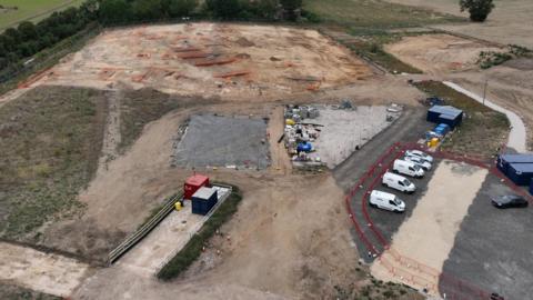 A large patch of ground with some vans parked up nearby.