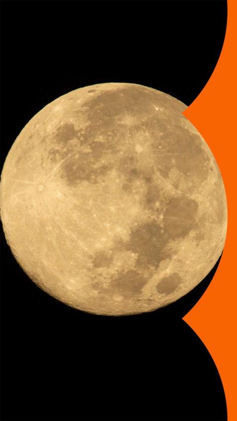 Full Moon at night against pitch black sky