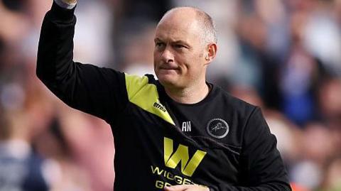 Alex Neil raises his fist to salute the Millwall fans