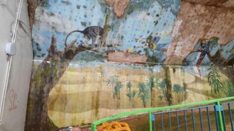 A monkey mural inside the Oasis. It is covered in damp and mould.