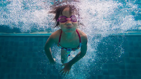 A child in goggles under water