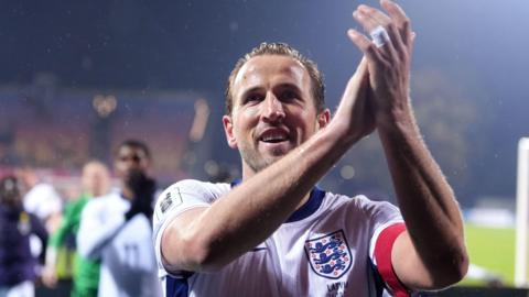 Harry Kane wears his England kit as he applauds fans in the crowd following his team's FIFA World Cup European Qualifying match in Riga.