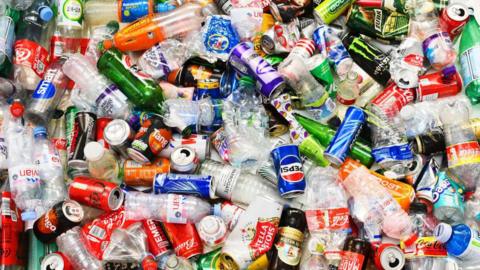 A colourful image of a large and varied collection of bottles and cans, hopefully ready for recycling - they include a range of recognisable brands of both soft and alcoholic drinks as well as water and sports drinks.