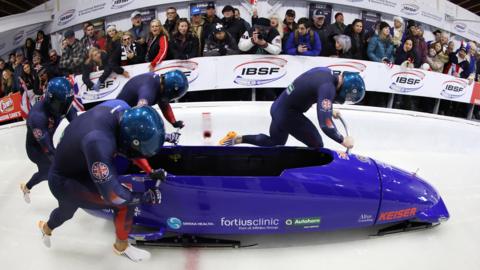 Great Britain's four-man bobsleigh team start a run