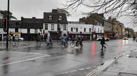 Pedestrians and cyclists crossing the road in Cambridge city centre