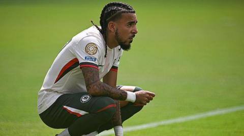 Malo Gusto of Chelsea crouching down on the pitch