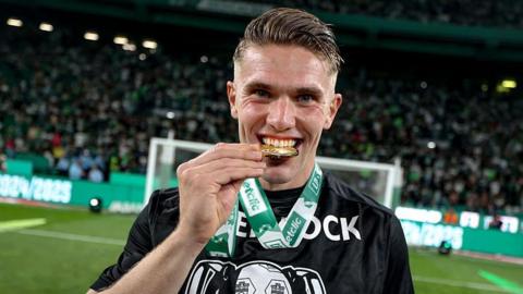 Viktor Gyokeres bites his title winner's medal