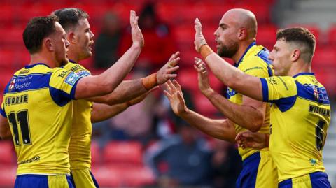 Warrington players celebrate a try by James Harrison (second right)