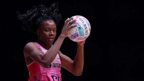 Funmi Fadoju holds the ball in her hands. She has black hair, tied up, and is wearing London Pulse's pink kit.