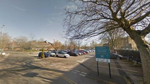 Signage and parked cars at The Sands car park in Carlisle