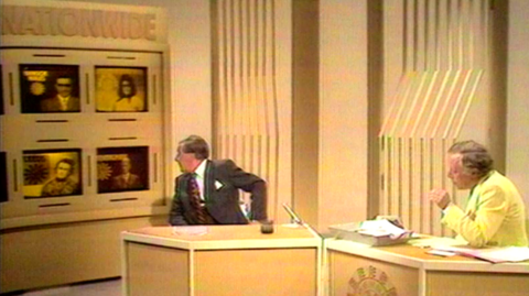 Two men, wearing suits, sit in the Nationwide studio