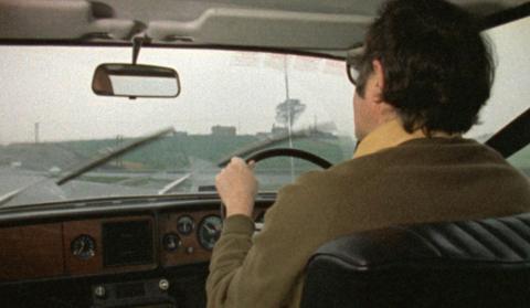 James Burke driving a car.