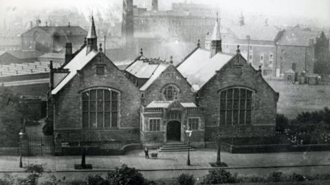 Photograph of the Touchstones Rochdale library in 1894. The image is from the Rochdale Council archives and includes factory chimneys in the background.  