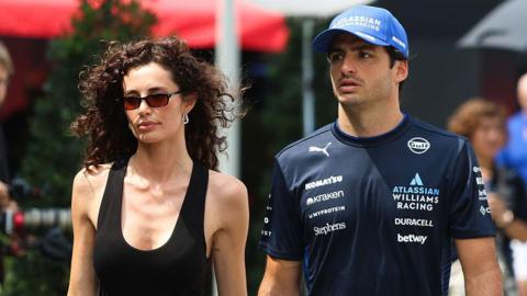 Rebecca Donaldson and Carlos Sainz walk into the paddock in Singapore 