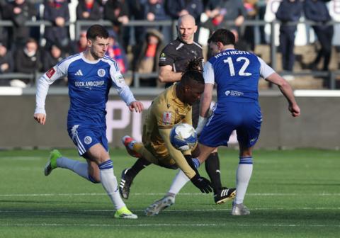 Two Macclesfield players tackle a Crystal Palace player as the referee looks on