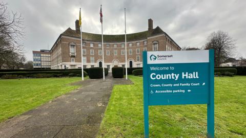 County Hall in Taunton with flags flying outside and a grey sky above