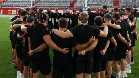 Wales players in a huddle at the Noevir Stadium