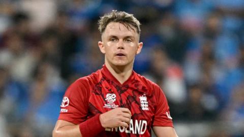 Sam Curran wearing a red England jersey