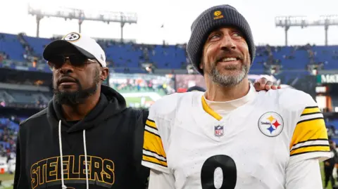 Pittsburgh Steelers head coach Mike Tomlin and quarterback Aaron Rodgers walk off the field after beating the Baltimore Ravens