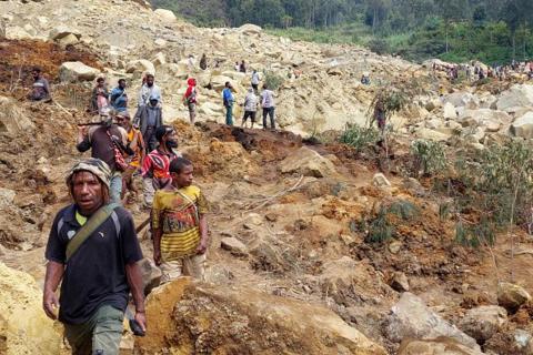 Locals gather at the site of a landslide at Mulitaka village in the region of Maip Mulitaka, in Papua New Guinea's Enga Province on May 26, 2024. 