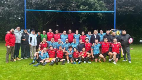 Llandaff RFC and Kyrgyzstan Rugby embrace in a post-match photo.