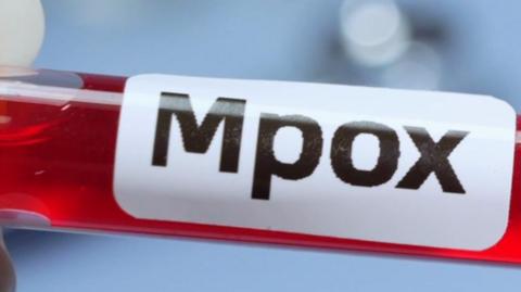 a red test tube with an Mpox label on it
