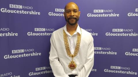 Mayor of Gloucester Adrian Graham wearing his ceremonial chain stares into camera in photo taken at BBC Radio Gloucestershire studios 