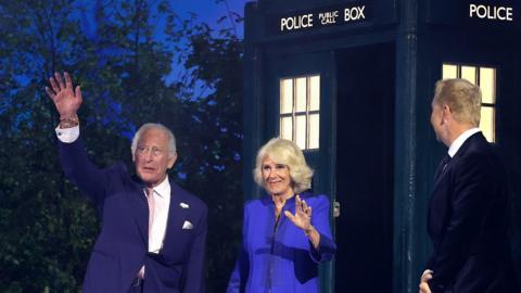 King Charles III and Queen Camilla emerge from a Tardis at the Commonwealth Games opening ceremony and wave, as a kilted Sir Chris Hoy greets them