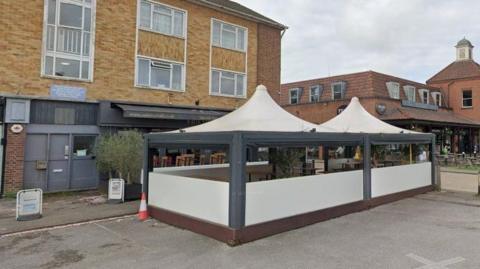  Exterior of Vall de Cavall tapas bar with cream-coloured covered seating area outside