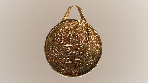 A circular bronze coloured medal that reads 'Bupa Great North Run' 