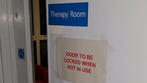 The outside of and door to the therapy room where Jessica Powell was found. There is a sign that says 'Door to be locked when not in use'.