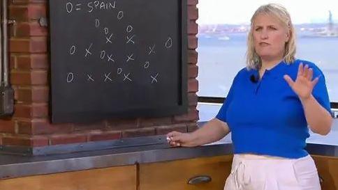 Pundit Emma Hayes standing in a kitchen analysing tactics with a chalk board