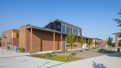 Queen Elizabeth School - a modern-looking building of pale brick with a large portico supported by bright yellow columns