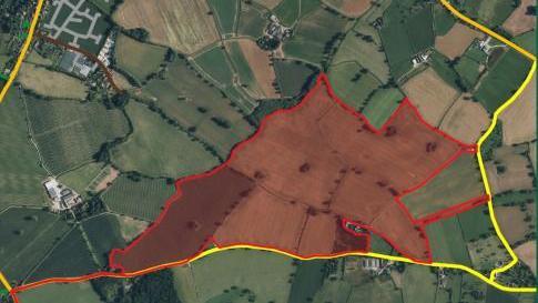 A map of a rural area showing a number of fields in red - denoting the site of a solar farm - and yellow lines depicting nearby roads